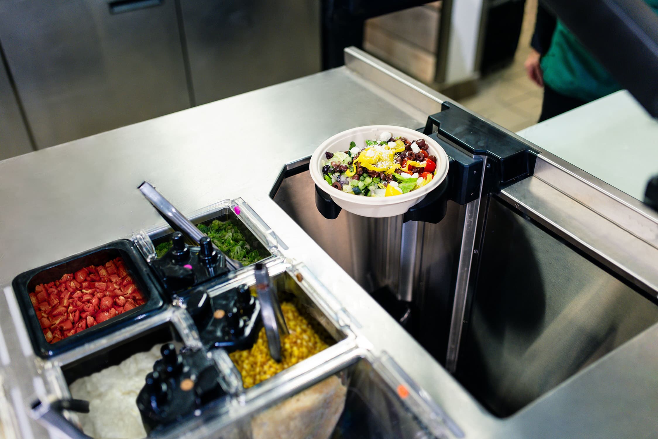 Hyphen makeline assembling a bowl with fresh ingredients